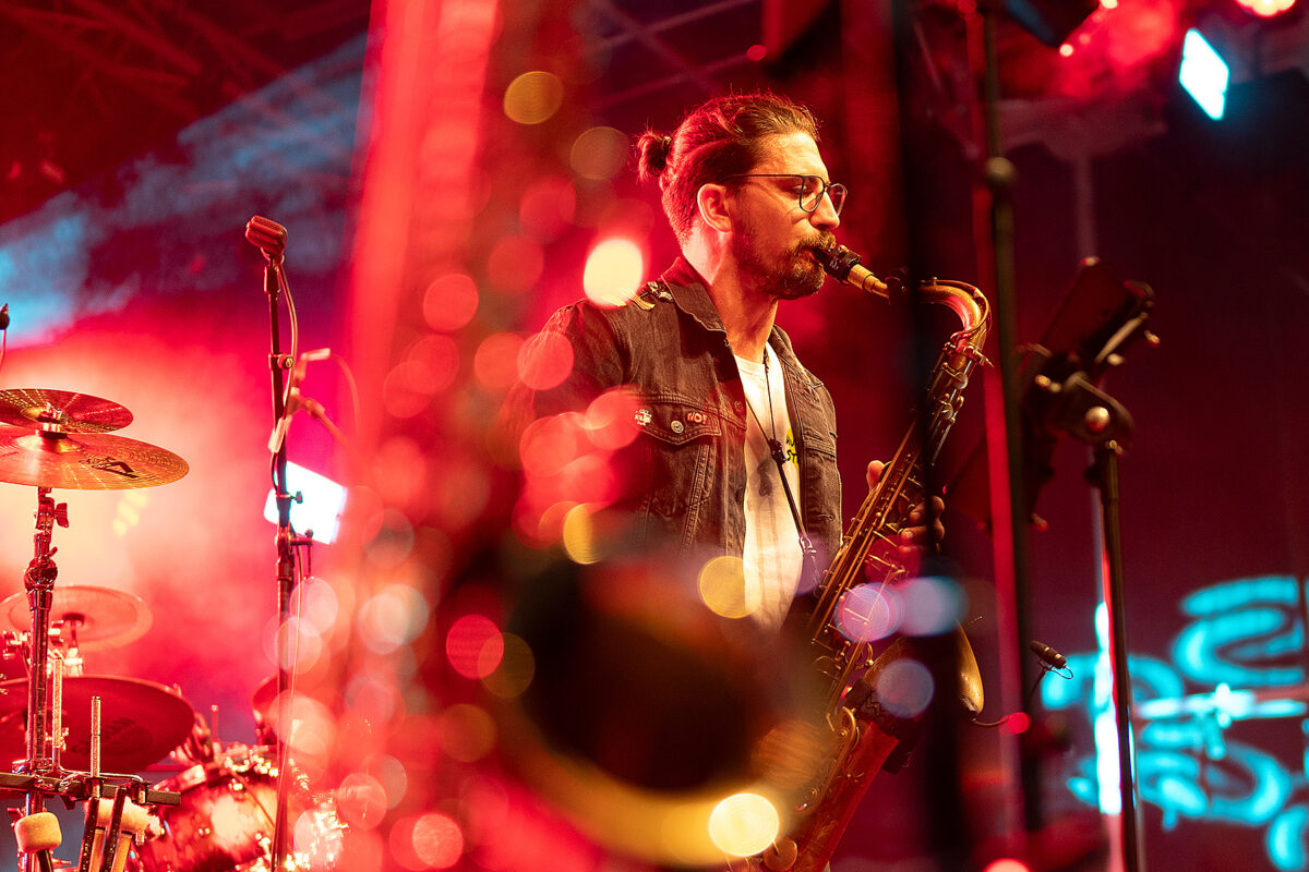 Saxophonist of Hunneg-Strëpp live on stage in red light, event photography for organisers by Am Fokus Luxembourg